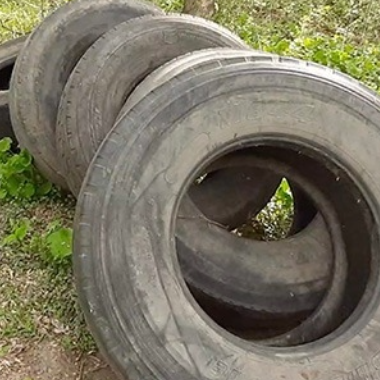 Old tires laying in a pile on the grass
