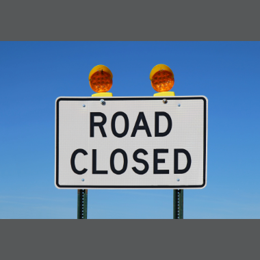 Road Closed sign with a clear blue sky in the background