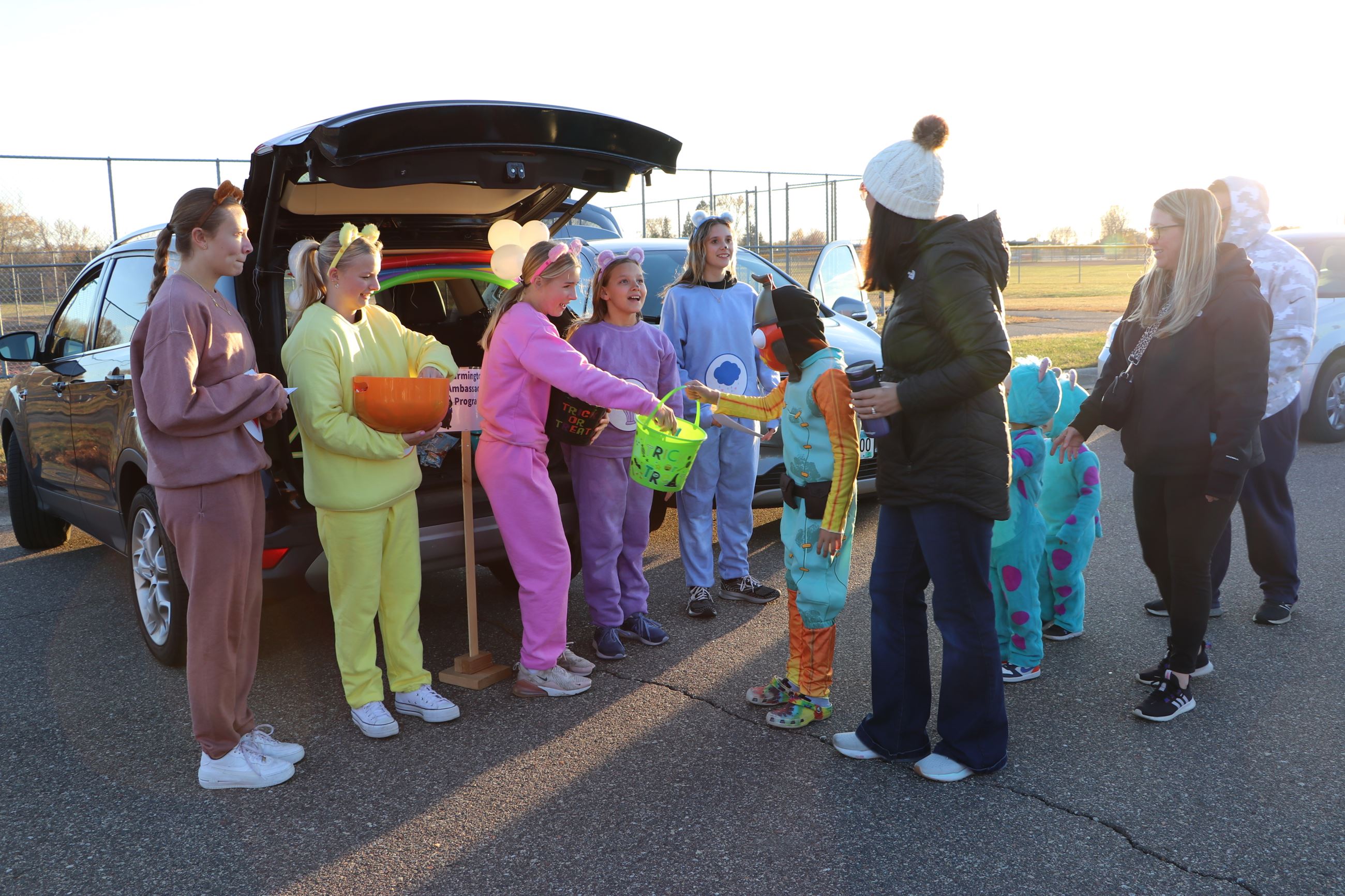 Farmington Ambassadors dressed as Care Bears for Halloween Walk passing out candy