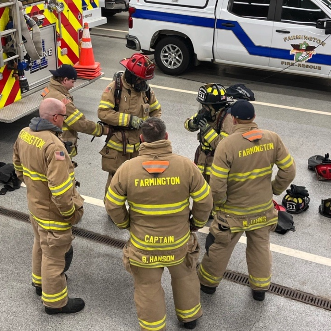 Six full-time firefighters standing in a circle during training at the fire station