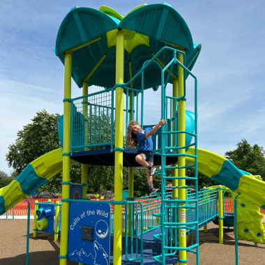 Rambling River Park Playground Structure with kid climbing