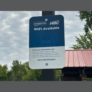 Hiawatha Broadband Communications Inc. WiFi sign posted on a pole in a park